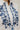 Détail des broderies florales bleues sur chemise blanche femme