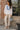 Chemise brodée femme blanche et bleue portée avec un pantalon écru