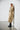 Manteau long crème WITHBLACK porté avec des bottes noires